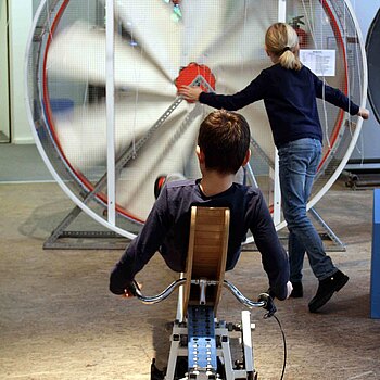 Kinder bedienen durch Bewegung ein Windrad
