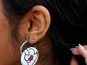 Ein Mädchen hat einen selbst gestalteten Magnet an ihrem Ohrring befestigt.
