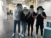 Mehrere Jugendliche in der Lothringer 13 halten sich selbst gezeichnete Masken vor ihre Gesichter.