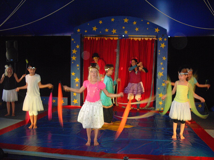 Kinder führen ein Stück auf der Bühne auf und sind verkleidet