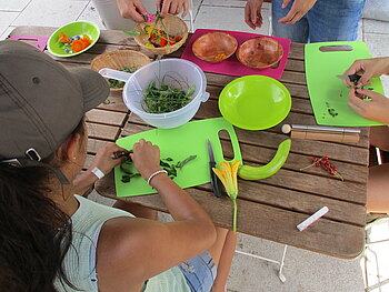 Kinder bereiten Essen aus dem Gemeinschaftsgarten vor