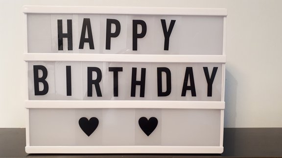 In einem beleuchteten Setzkasten ist mit Buchstaben gesetzt: "Happy Birthday".  
