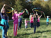 Kinder spielen mit Bändern in der Luft herum