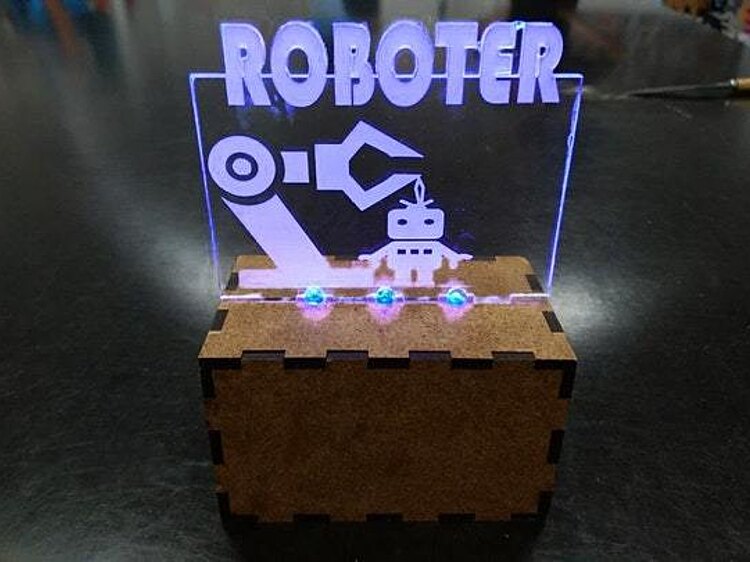 Ein Schild aus Plexiglas zeigt leuchtend das Wort "Roboter".