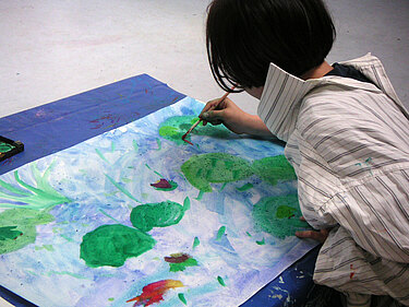 Mädchen malt Wasserlilien mit Wasserfarben