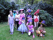 Eine Gruppe an Kindern ist verkleidet und posiert auf einer Wiese