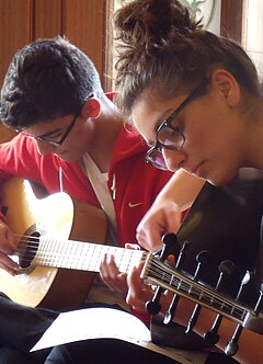 Zwei Jugendlichen spielen Gitarre