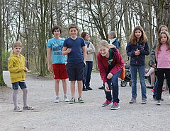 6 Kinder spielen Murmelspiel auf Weg im Schlosspark Nymphenburg