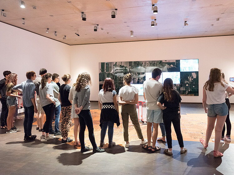 Eine Gruppe Jugendlicher steht während eines Vermittlungsprogramms in der Dauerausstellung des Jüdischen Museums München.