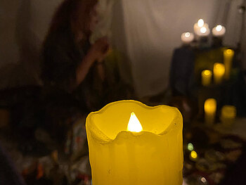Eine Kerze aus Plastik die in einem dunklen Raum leuchtet