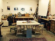 Die MachWerk Werkstatt von Innen mit Werkbank und Stühlen voller Farbe