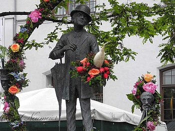 Bronzestatue des Valentin mit Blumenranken um sie herum