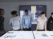 Fünf junge Männer betrachten ein Exponat im NS-Dokumentationszentrums München.