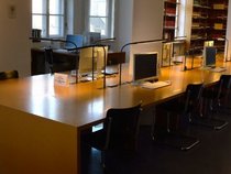 Stadtarchiv München Zimmer mit Langem Tisch, PCs und Bücherregalen