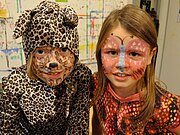 zwei Mädchen sind für Fasching als Leopard und Schmertterling geschminkt