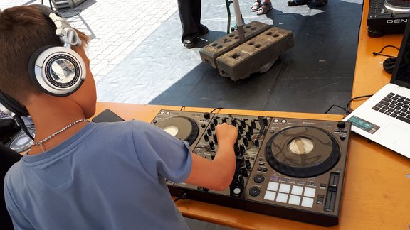 Ein Kind bedient einen DJ-Controller.