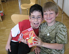 Zwei junge Leser mit Freude in der Bibliothek der Stiftung Pfennigparade