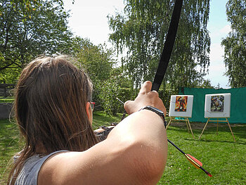 Mädchen schießt mit Pfeil und Bogen