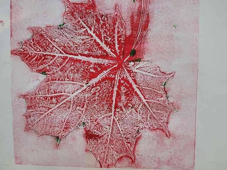 Roter Abdruck eines Ahornblatts auf Papier
