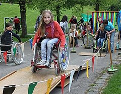 Gehbehinderte Kinder bestreiten einen Rolli-Parcours