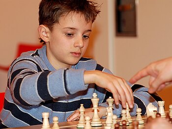 Ein Junge macht einen Zug in seinem Schachspiel