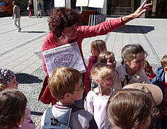 Eine Stadtführerin mit einer Gruppe von Kindern