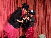 Zwei Mädchen tragen Polizeikappen und spielen auf der Bühne