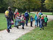 Kinder gehen mit ihren Erziehern spazieren in einem Park
