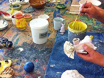 Kind bemalt selbst getöpftere Keramik mit bunter Farbe