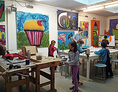 Kinder malen und basteln in einem Raum mit Graffiti-Bildern an den Wänden