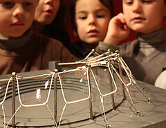Kinder beobachten ein Seifenblasenexperiment in der Architekturwerkstatt