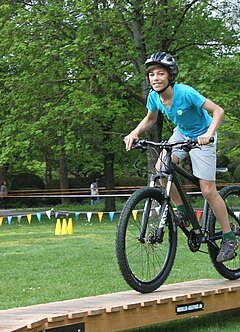 Ein Junge fährt mit seinem Mountainbike einen Parcour