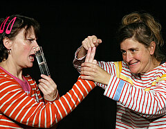Zwei Schauspielerinnen interagieren auf der Bühne