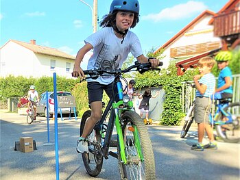 Ein Junge nutzt die Spielstraße als Fläche zum Radfahren