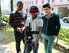 Drei Männer filmen mit einer Videokamera