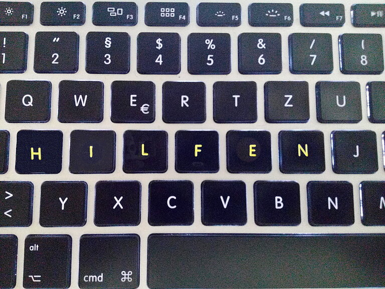 Tastatur eines Laptops, auf deren Tasten das Wort "Hilfen" geschrieben steht. 