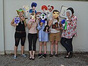 Eine Gruppe von Personen trägt Papiermasken für das Gruppenfoto